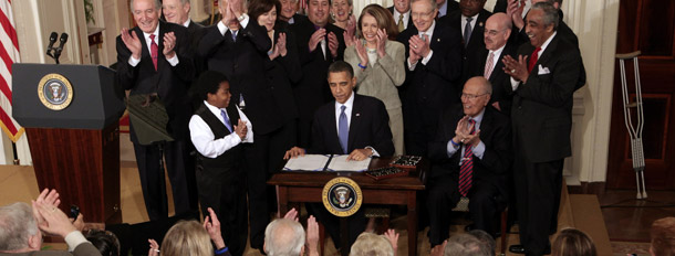 President Barack Obama is applauded as he signs the health care reform bill, on March 23, 2010, in the East Room of the White House in Washington. The bill includes many benefits for Americans who have health insurance today and those who have struggled to find and maintain health coverage. (AP/Charles Dharapak)