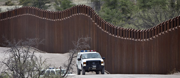 Customs and Border Patrol agents line the international border in Nogales, AZ. The reform package that would make the greatest immediate strides in strengthening the nation’s immigration system includes a combination of employment verification and border security measures plus a program to require undocumented workers to earn legal status. (AP/Matt York)