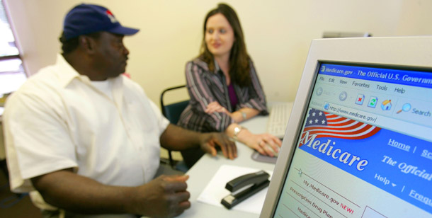 A care coordinator at CareLink Central Arkansas Area Agency on Aging Inc., helps a man sign up for the Medicare prescription drug program. The Affordable Care Act establishes discounted drug prices for individuals who hit the so-called “doughnut hole” in the Medicare Part D benefit. (AP/Danny Johnston)