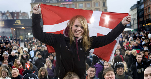 A girl holds up a Denmark flag in City Hall Square in Copenhagen, Denmark. According to the Economist Intelligence Unit, Denmark’s “Quality of Life” index proved superior to that of America, with advantages like universal health care and day care, and an extremely low poverty rate that’s not even a quarter of that of the United States. (AP/POLFOTO, Thorkild Amdi)