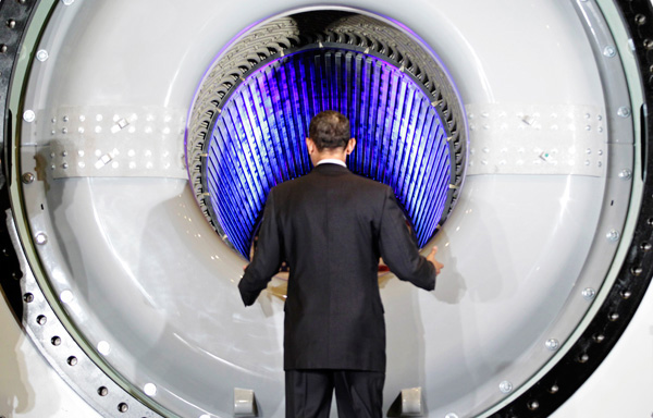 President Barack Obama peers into a high-tech hydrogen-cooled generator as he tours a GE plant in Schenectady, New York, to talk about clean energy and green jobs.  (AP/J. Scott Applewhite)