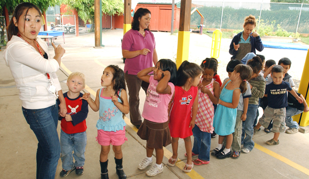 Teacher Dany Chhy, left, leads a drill as preschoolers line up before their lunch break at a Head Start program in Hillsboro, Oregon, Thursday, August 16, 2007. Under H.R. 1, funding for Head Start would be cut by $1 billion, eliminating almost 196,000 enrollment slots for low-income children nationwide. (AP/Greg Wahl-Stephens)