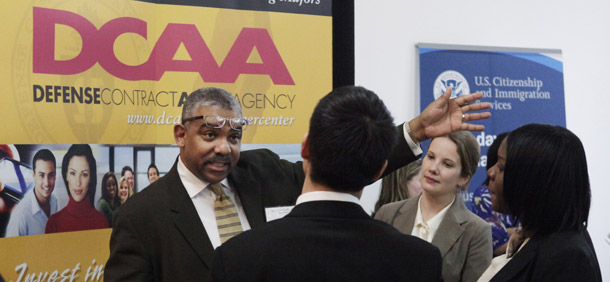 Defense Contract Audit Agency recruiters talk with job fair participants during a job fair at Roosevelt University in Chicago. DCAA's oversight of contract dollars has expanded manifold since its inception 46 years ago, but its staff has shrunk. (AP/Charles Rex Arbogast)