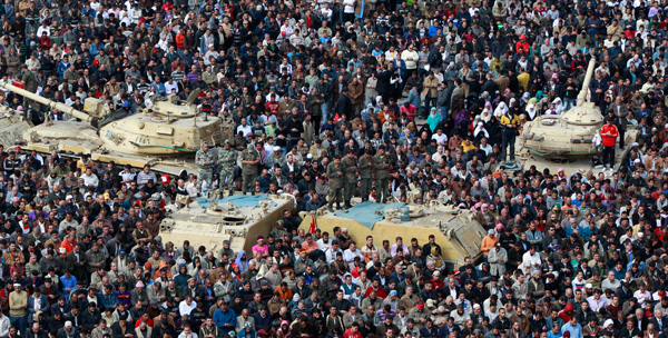 Anti-government protesters, and Egyptian soldiers on top of their vehicles, make traditional Muslim Friday prayers at the continuing demonstration in Tahrir Square in downtown Cairo. Nonviolence as an effective method of social and political change may be making some headway in the Arab world.
<br /> (AP/Ben Curtis)