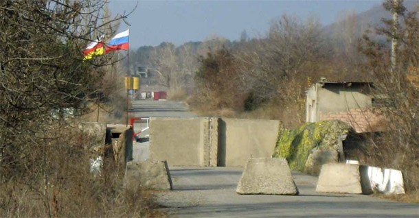 South Ossetian and Russian flags fly over the main checkpoint at the South Ossetia conflict line. (Photo by authors)