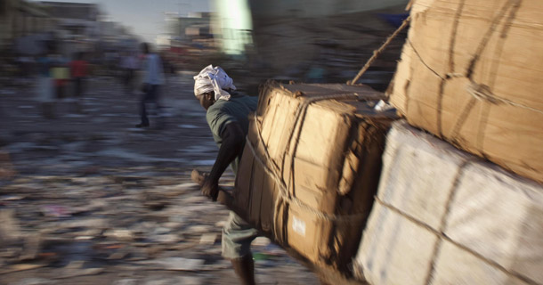 A man pulls a cart with merchandise past quake-damaged buildings in downtown Port-au-Prince, Haiti, on January 6, 2011. (AP/Ramon Espinosa)
