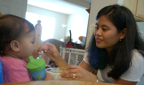 María Prince le da de comer a su hija Mónica de un año en su hogar en Crofton, Maryland. María recibe beneficios de WIC, uno de los programas truncados en el más reciente plan republicano para recortar déficit presupuestario federal. (AP/Jacqueline Malonson)