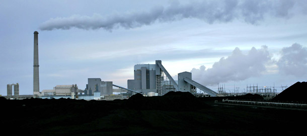 Sunflower Electric Cooperative's coal-fired power plant rises behind a 30-day-supply of coal in Holcomb, Kansas. The 2011 House spending bill would halt the Environmental Protection Agency from protecting us harmful pollutants from coal-fired power plants, and it fails to invest in oil reduction and clean energy technologies. (AP/Charlie Riedel)