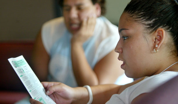 Solimar Lopez, a student at Worcester Vocational High School, looks over the Federal Application for Student Aid. (AP/Tim Boyd)