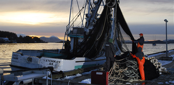 The crew of the Lovey Joann mends their net at the Thompsen Harbor in Sitka, Alaska. (AP/Chris Miller)