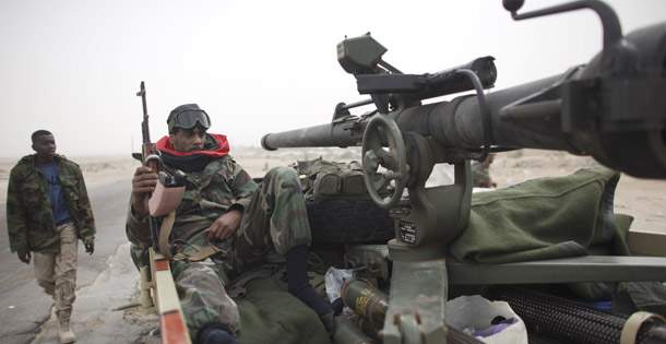 A defected Libyan soldier sits with his weapons on the outskirts of the eastern town of Brega, Libya, on March 4, 2011. (AP/Tara Todras-Whitehill)