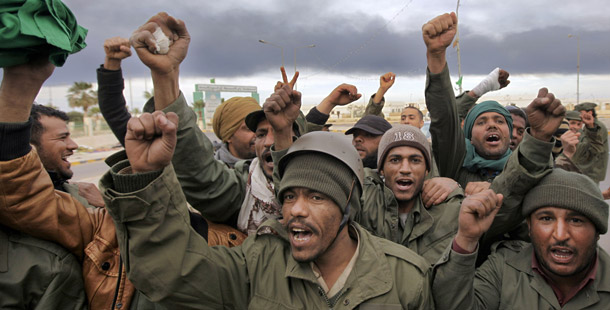 Pro-Qaddafi fighters raise their fists to indicate victory near Ras Lanouf, 380 miles southeast of the capital Tripoli in Libya on March 12, 2011. Western diplomats, aid agencies, and legislatures are still prone to the same types of approaches—both good and bad—that they employed in the early 1990s. They are already replicating some of these missteps in the Middle East. (AP/Ben Curtis)