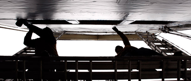 Construction workers fasten insulation to the outside of a house in Arlington, Massachusetts. Certain types of structural upgrades, such as energy efficient insulation, are eligible for tax credits worth 10 percent of the upgrade’s value, up to $500. (AP/Winslow Townson)