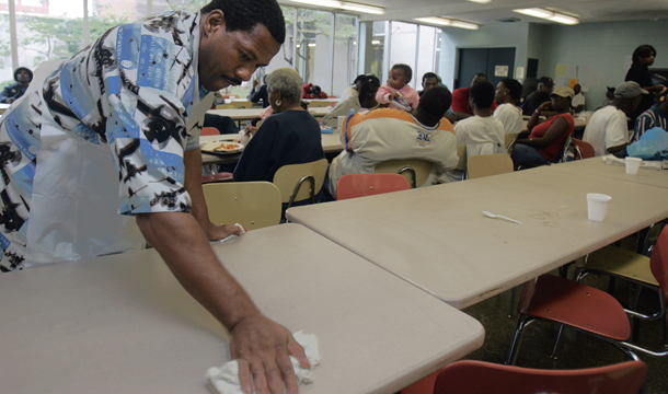 Alfred Reese wipes down tables at the meals program for Cleveland Catholic Charities at the Bishop Cosgrove Center. Faith-based organizations and houses of worship are a crucial part of our social service network, offering health care, food pantries, day care, counseling services, housing assistance, job assistance, and other programs. (AP/Tony Dejak)