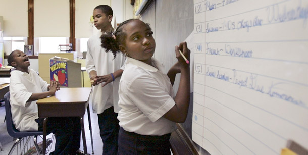 A sixth-grader copies her homework assignment from a  list on the board at the Kellogg Elementary School in Chicago. A new bill in the Illinois state legislature protects students from chronically low-performing teachers by streamlining the dismissal process, and it would put in place other reforms to get the most effective teachers in the classroom. (AP/Charles Rex Arbogast)