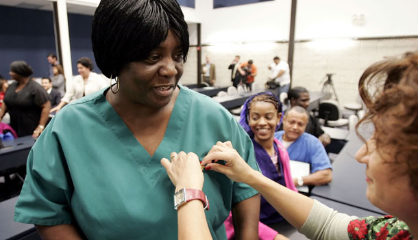 Angelean Edwards is helped with a nursing pin by her instructor after receiving her certified nursing assistant certificate she earned through a jobs training program. (AP/Eric Gay)