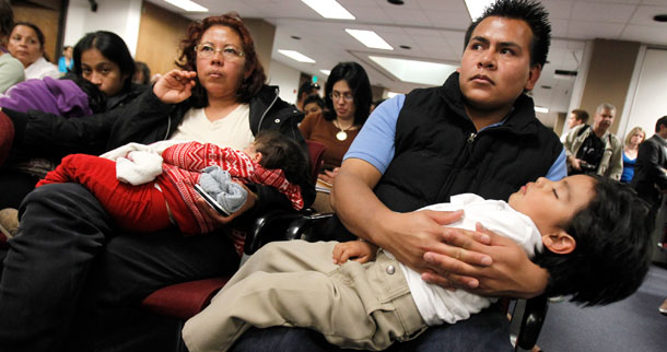 Marko Garduno, derecha, tiene en brazos a Dillon Garduno, 2 1/2, en la primera audiencia para un proyecto de ley en Arizona que recusa la ciudadanía automática para los hijos de todos los inmigrantes ilegales. (AP/Ross D. Franklin)