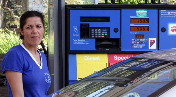 Sandra Martins of Hyannis, Massachusetts, adds gas to her car at a Mobil station. The 2009 Consumer Expenditure Survey  shows that Latinos on average spent a full percentage more of their  income on gasoline and motor oil than the rest of the population that  year. (AP/Celina Fang)