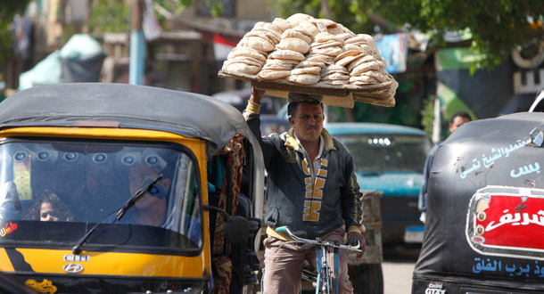 An Egyptian bread vender carries a tray full of his produce on his head in Cairo, Egypt. (AP/Amr Nabil)