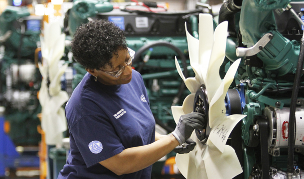 Terri Lewis installs a fan on a diesel engine on the Volvo truck assembly line at the Volvo plant in Dublin, Virginia. (AP/Steve Helber)