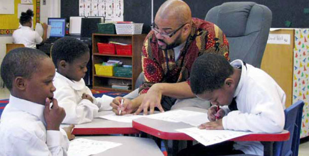 Teacher Calvin Hobbs works with students at Timbuktu Academy of Science and Technology in Detroit. (AP Photo)