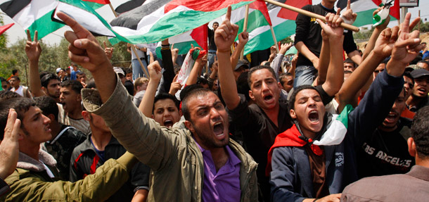 Demonstrators in Erez crossing between  Israel and northern Gaza wave Palestinian flags during a rally marking the 63rd  anniversary of "nakba," the term used to mark  the events leading to Israel's founding in 1948, on May 15, 2011. (AP/Hatem Moussa)