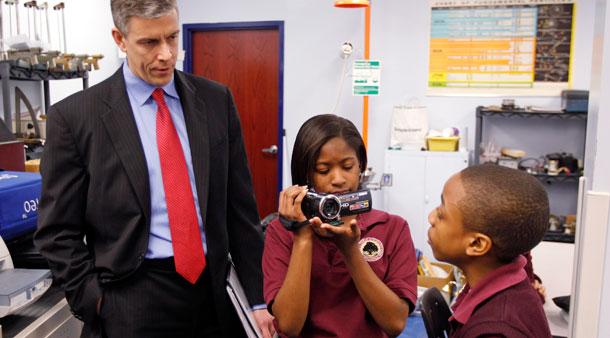 U.S. Department of Education Secretary Arne Duncan is questioned by student Trebor Goodall, right, as he's videotaped by fellow student Faith Brown during a school tour in Indianapolis. (AP/Michael Conroy)