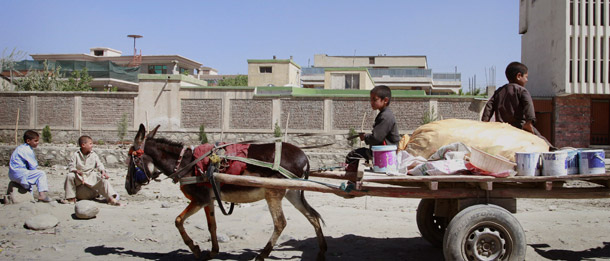 Afghan boys ride a donkey as they transport goods in Kabul, Afghanistan, on April 26, 2011. Afghanistan’s economy today is largely driven and supported by war spending and development assistance, and a key part of the transition is helping Afghans craft a sustainable economic strategy. (AP/Musadeq Sadeq)