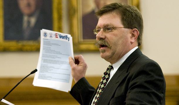 Businessman Chris Barbee holds up a copy of instructions for the E-Verify system at the Statehouse in Topeka, Kansas. E-Verify is already in use by an estimated 4 percent of American employers, but expanding it for use by all U.S. businesses, from the mom-and-pop grocery store, to the biggest employers in the nation, presents onerous and expensive challenges. (AP/Chuck France)
