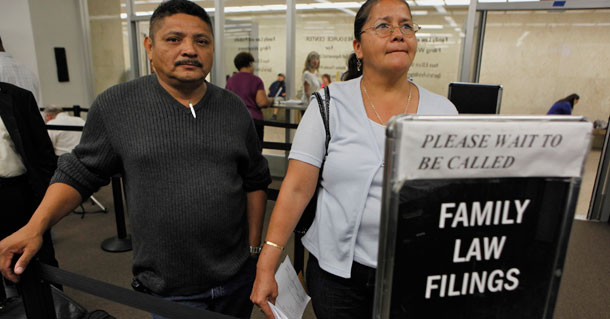Hilda Garcia, right, and Marcial Guardado wait to finalize filling their divorce papers at a free divorce workshop at the Los Angeles County Superior Court's Resource Center for Self-Represented Litigants. More people are opting to represent themselves in civil court matters because they don't have the money to afford an attorney. (AP/Damian Dovarganes)