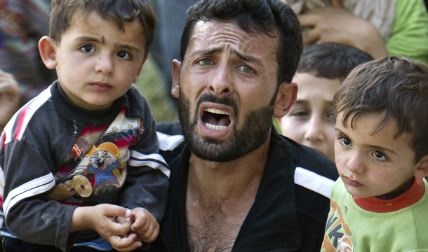 A Syrian refugee man surrounded by children shouts during a spontaneous protest against Syrian President Bashar al-Assad in a camp in Yayladagi, Turkey, near the Syrian border, Wednesday, June 15, 2011. (AP/Vadim Ghirda)