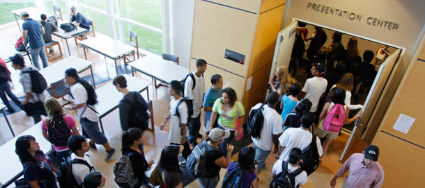 Students rush in to a lecture hall to get a seat for a chemistry class  at the California State University East Bay in Hayward, California. Graduation rates at accredited for-profit colleges and community colleges are low, and studies suggest that students may not be learning much at four-year schools. (AP/Eric Risberg)