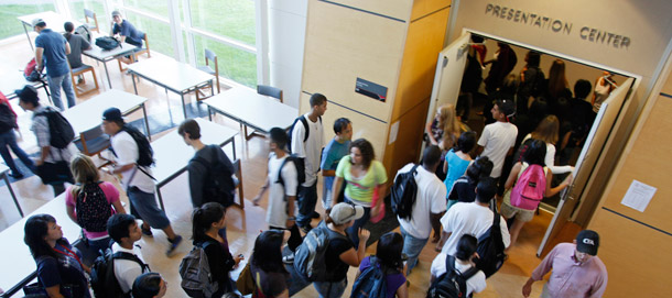 Students rush in to a lecture hall to get a seat for a chemistry class at the California State University East Bay in Hayward, California. Graduation rates at accredited for-profit colleges and community colleges are low, and studies suggest that students may not be learning much at four-year schools. (AP/Eric Risberg)