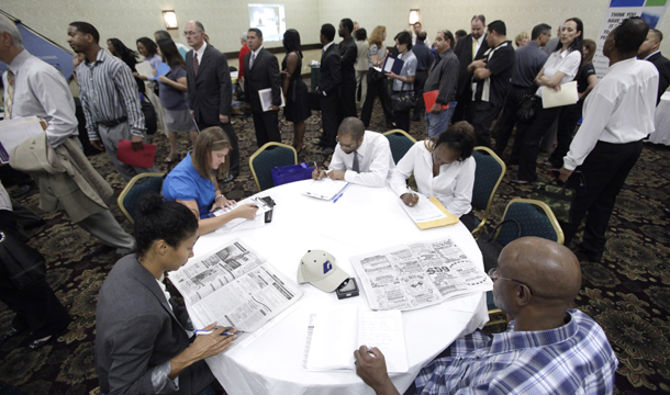A large line of attendees wraps around the room as others sit filling out applications and looking through classifieds during a National Career Fairs job fair Wednesday, July 13, 2011, in Dallas. Businesses are worried about Congress’s inability to come  to an agreement on the debt ceiling that protects economic growth, and they are putting off hiring in this time of heightened economic uncertainty. (AP/Tony Gutierrez)