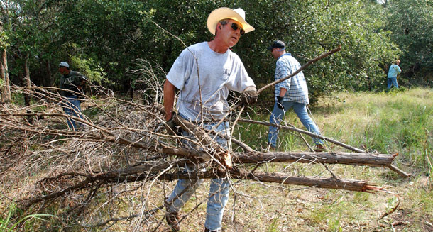 Former President George W. Bush clears cedar at his 1,600 acre ranch in Crawford, Texas, Friday, Aug. 9, 2002, where stayed for a nearly month-long vacation. (AP/Eric Draper)