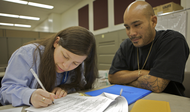 Justice Corps Fellows volunteer Aura Armas, left, helps fill divorce legal forms for Daniel Noiboonsook, right, at the Los Angeles County Superior Court's Resource Center for Self-Represented Litigants, Monday, September 14, 2009, in Los Angeles. (AP/Damian Dovarganes)