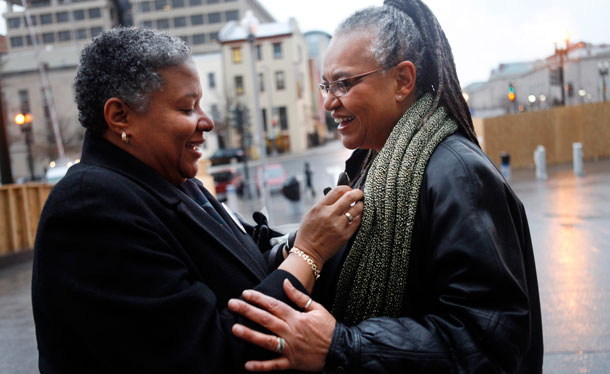 Candy Holmes, left, affixes a marriage equality pin to her partner of 14 years, Darlene Garner, on arriving at the Superior Court to obtain their marriage licenses after the District of Columbia legalized gay marriage in Washington. (AP/Jacquelyn Martin)