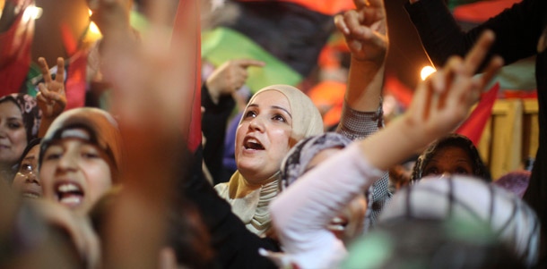 People celebrate the capture in Tripoli of Moammar Gadhafi's son and  one-time heir apparent, Seif al-Islam, at the rebel-held town of  Benghazi, Libya, early on August 22, 2011. The country will still need international assistance as it transitions from Qaddafi's rule. (AP/Alexandre Meneghini)