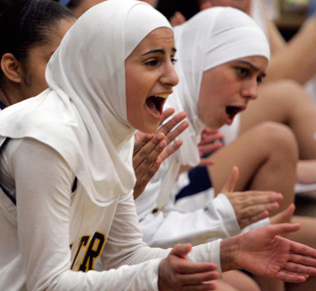 Two students cheer on their teammates on the basketball court. A new Gallup poll finds that the Muslim American community at large is engaged and optimistic, and that its youth have also begun to share in this same sense of hopefulness about the future. (AP/Carlos Osorio)