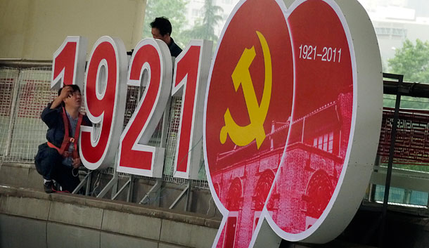 Workers set up the advertisement to celebrate the upcoming 90th anniversary of the founding of the Communist Party of China on a pedestrian bridge in Shanghai, China. (AP/Eugene Hoshiko)