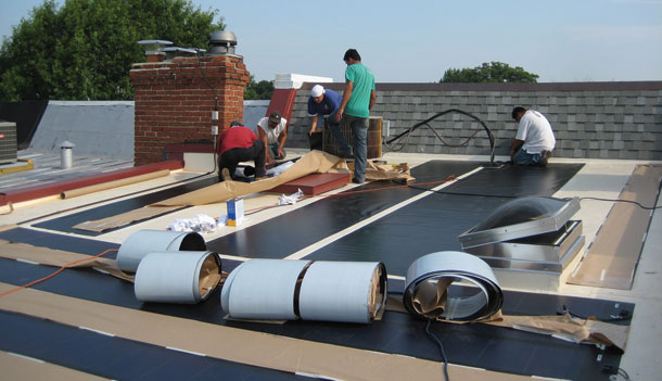 Workers install solar shingles on a house in Washington, D.C. (Flickr/Bread for the World)