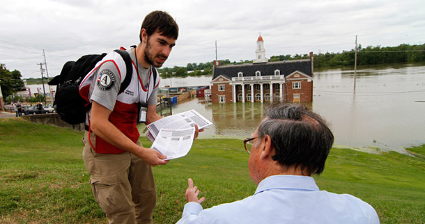 AmeriCorps volunteer Jacob Biddlecome, 24, from Maryland hands out Red Cross informational flyers on how to return to your flooded home in Vicksburg, Mississippi, on May 14, 2011. Recent budget cuts to national service programs rob youth of the chance to make a difference in their country. (AP/Rogelio V. Solis)
