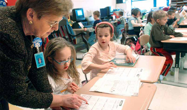 Sandy Gay, second-grade teacher at Princeton Primary School, helps, from left to right, Nikki Delgrande and Dottie Dillon with two-digit addition on Thursday, January 24, 2008. (AP/Jon C Hancock)