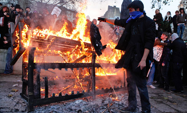 A demonstrator adds to a bonfire in London. (AP/Paul Jeffers)