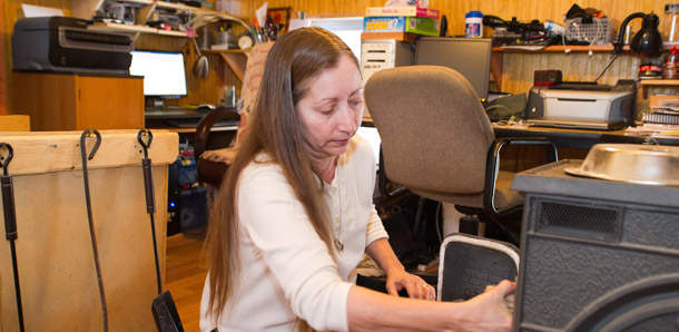 In this January 22, 2011 photo, Valerie Houde fills her wood stove while waiting for a dial-up Internet connection in East Burke, Vermont. The $3.5 billion in government investment for the Broadband Initiatives Loan and Grant Program brought high-speed internet connection to more than 7 million people and created or saved 25,800 jobs. (AP/Andy Duback)