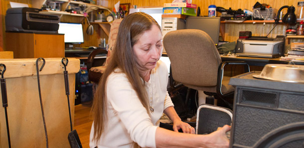 In this January 22, 2011 photo, Valerie Houde fills her wood stove while  waiting for a dial-up Internet connection in East Burke, Vermont. The $3.5 billion in government investment for the Broadband Initiatives Loan and Grant  Program brought high-speed internet connection to more than 7 million  people and created or saved 25,800 jobs. (AP/Andy Duback)