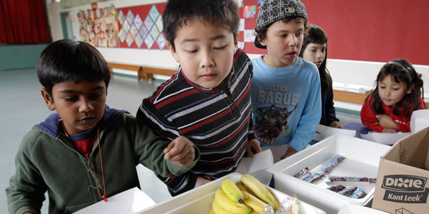 Fairmeadow Elementary School second-grade student Jonathan Cheng, center, looks at fruits and vegetables during a school lunch program in Palo Alto, California. It’s crucial to continue pursuing programs that keep up the fight against obesity in our children and communities. (AP/Paul Sakuma)