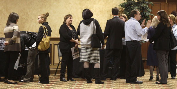 Job seekers talk with prospective employers at a job fair Wednesday, October 26, 2011, in Brookpark, Ohio. Private-sector job growth is too weak to improve the economic fortunes of America’s middle class, making jobs policymakers’ top priority. (AP/Tony Dejak)