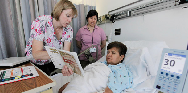 Registered nurse Mary Schlitter, left, speaks to heart patient Maria Marure, with the help of medical interpreter Marina Moreno at Our Lady of the Resurrection Medical Center in Chicago. Expanding the Acute Care Episode, or ACE, bundling program for cardiac and orthopedic procedures nationwide could reap significant savings. (AP/M. Spencer Green)