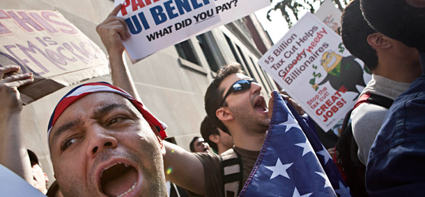 Protesters affiliated with the Occupy Wall Street protests wave signs and banners outside 1185 Park Avenue, where Jamie Dimon, CEO of JP Morgan Chase, lives, during a march in New York on October 11, 2011. (AP/Andrew Burton)